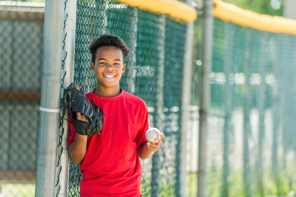 Youth Holding Baseball and Wearing Glove