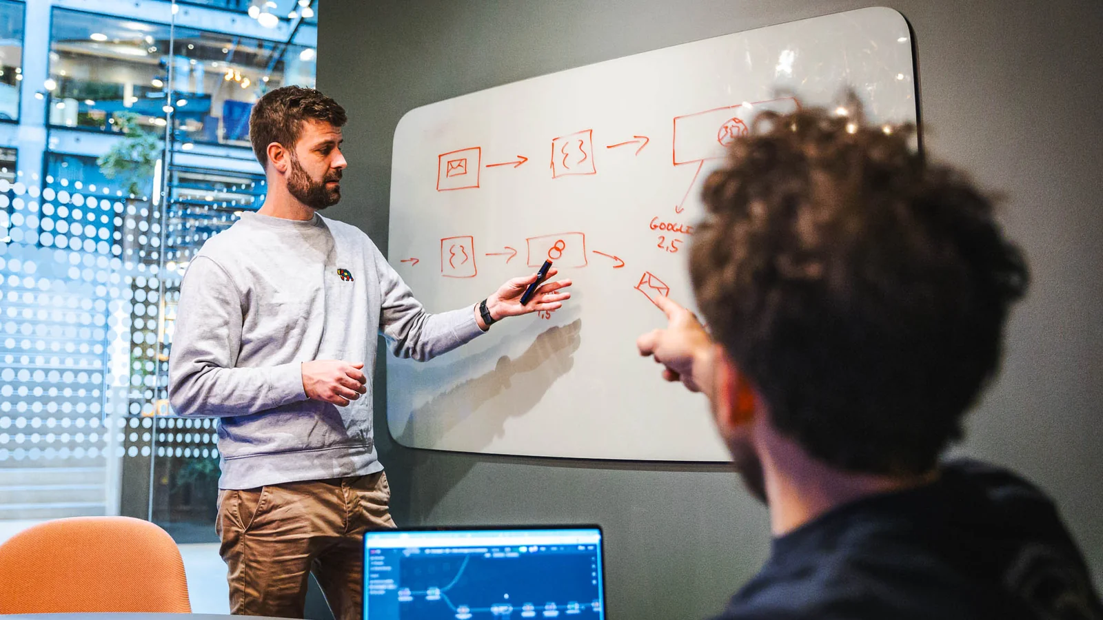 Jacob fra HverdagsAI underviser ved whiteboard om AI kompetence, mens en deltager følger med på laptop.