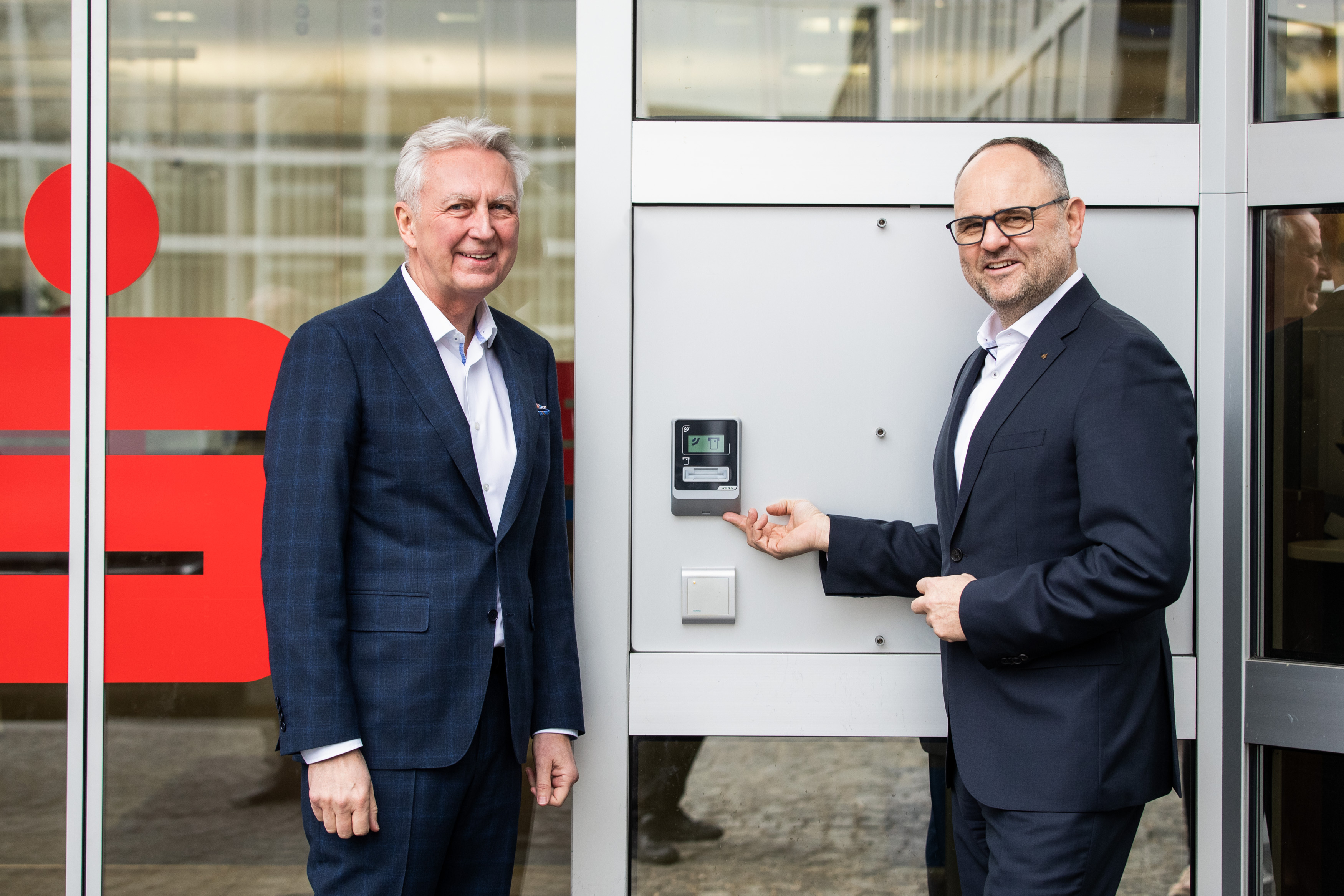 2 Herren stehen am KeBin S10 Türmodul bei der Filialtür