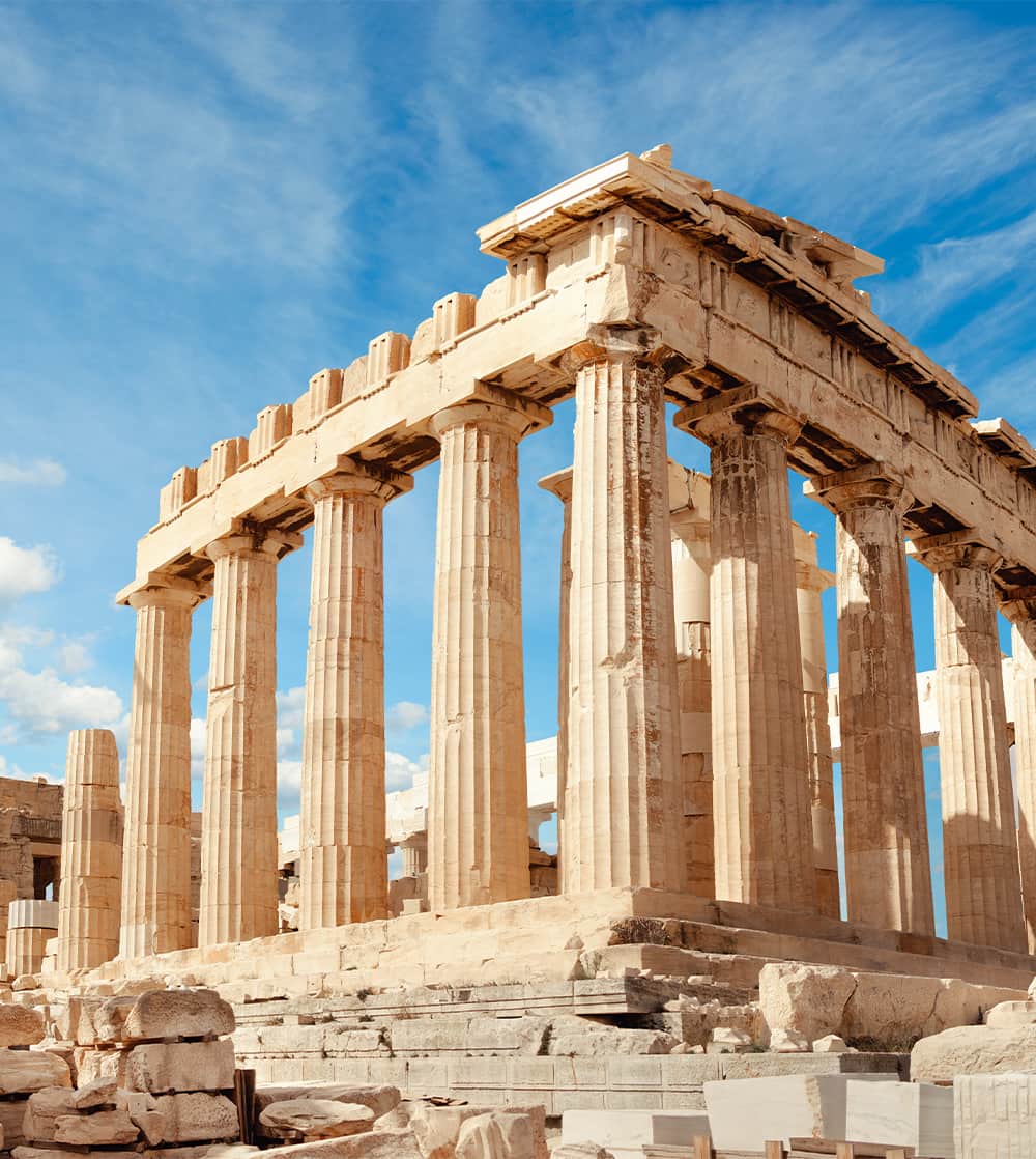 Ancient Greek ruins with many columns and a broken roof during a cloudy day