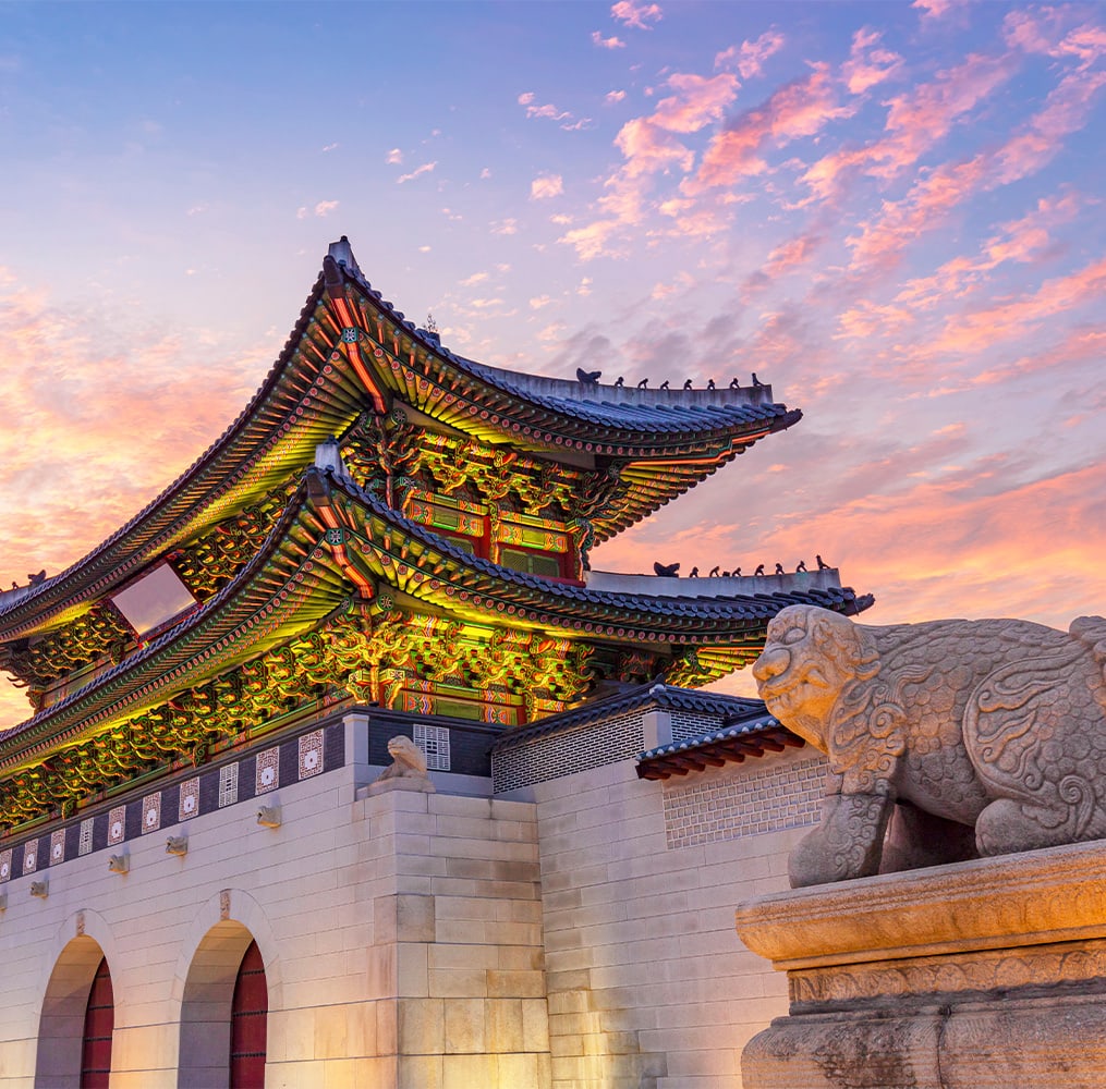 An ornately detailed temple with statues in front of it during sunset