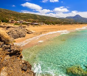 Crystal clear ocean meeting the shoreline of an empty beach in Greece