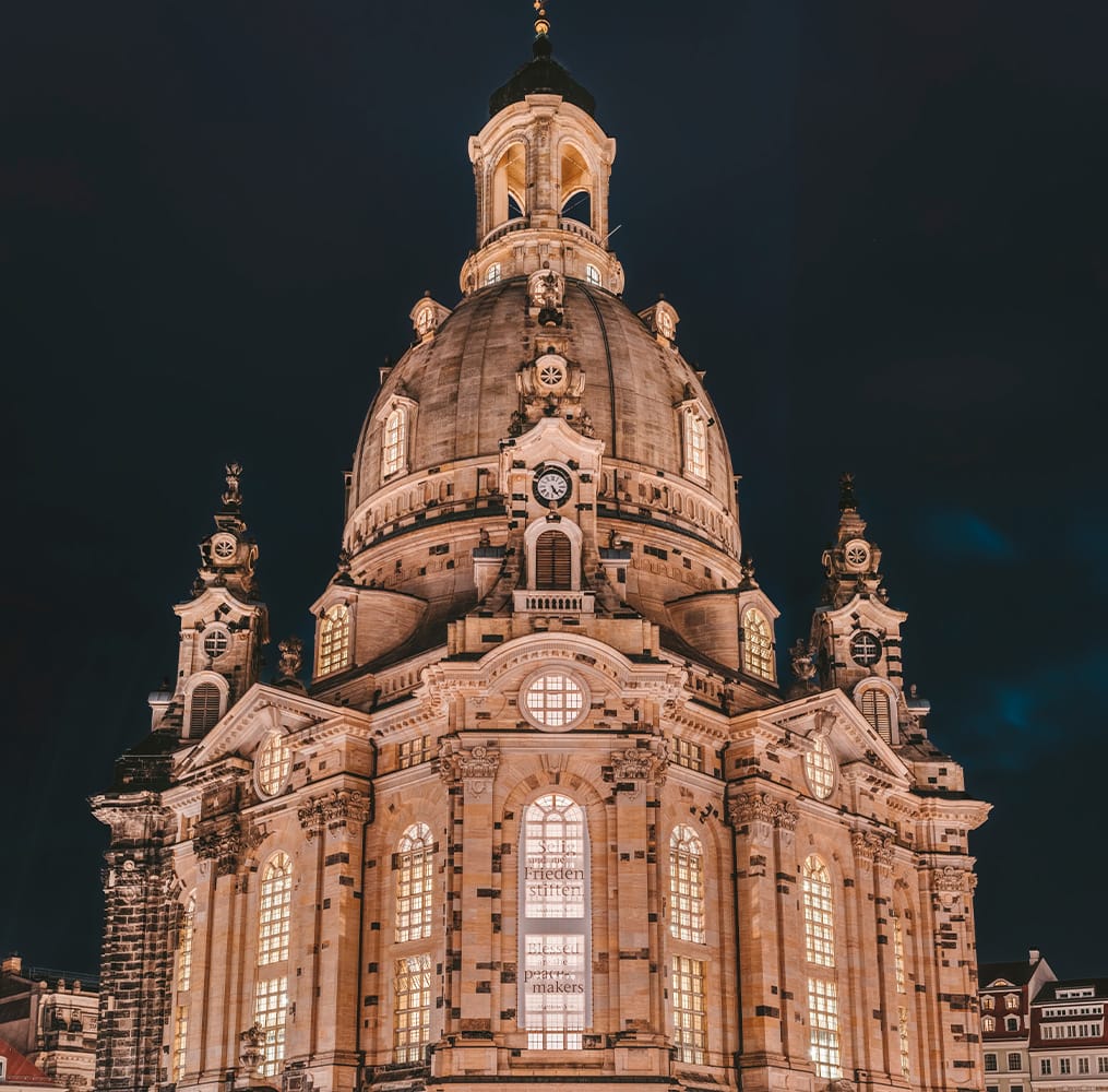 The top of an elaborate Gothic building lit up at night