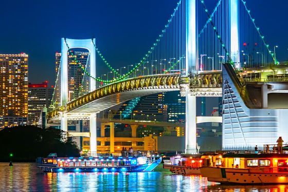A large bridge lit up with many colors at night