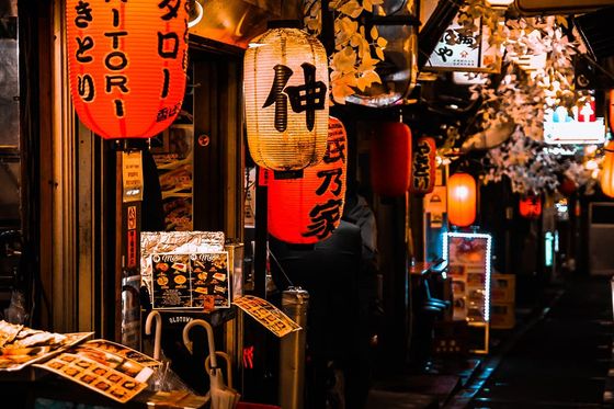 A storefront with several red and white lit up lanterns during nighttime