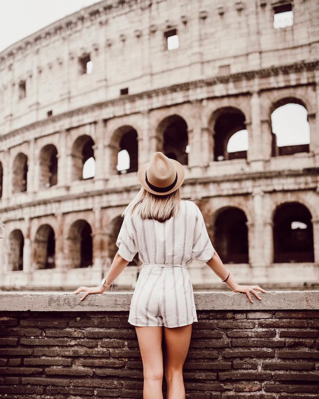 A girl looking at the Roman Colosseum.