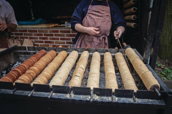 Trdelnik dough wrapped around a stick at a street vendor in Prague.