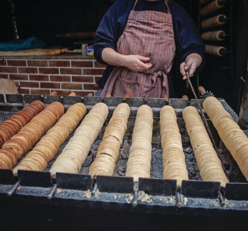 Trdelnik dough wrapped around a stick at a street vendor in Prague.