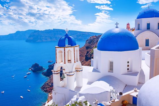 Sunny day in Santorini with close-up view of blue and white domed buildings