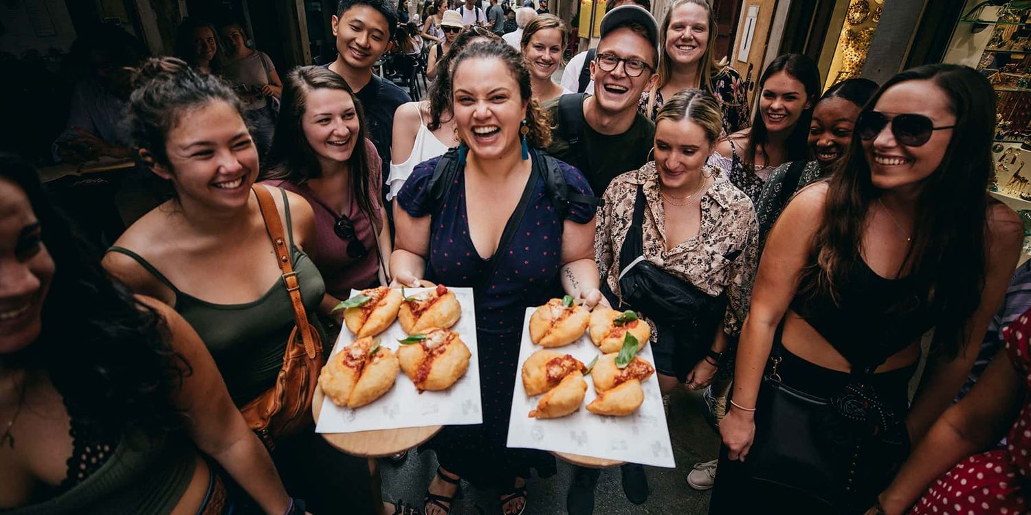 A Tour Director leading a group of travelers in a pizza tasting in Italy.