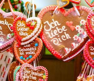 Heart-shaped cookies decorated in red and white frosting with German phrases