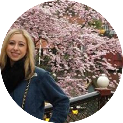 A woman posing in front of pink flowers