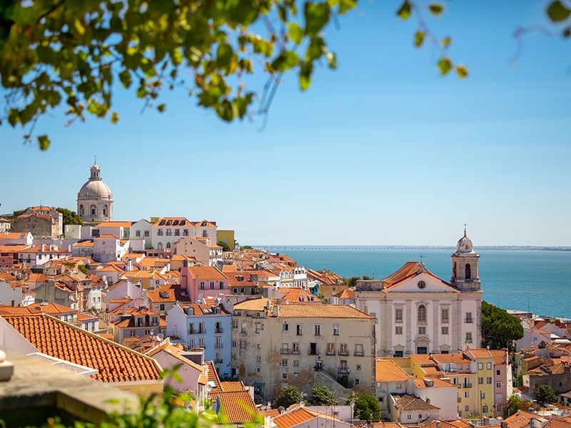 Lisbon buildings with orange roofs and ocean in the background