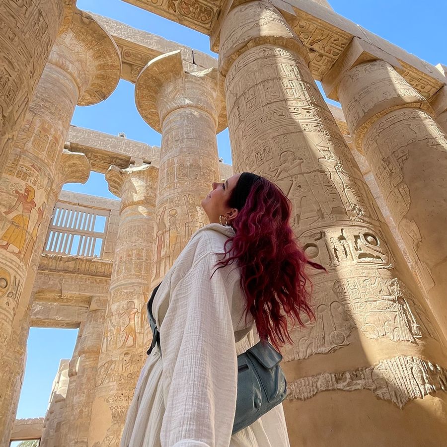 A woman in front of carved stone columns. 