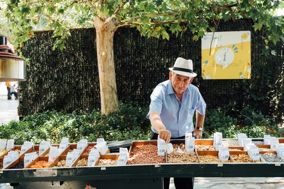 a street vendor selling nuts from his cart on a sunny day