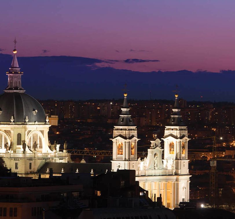 white building with black roof lit up at night