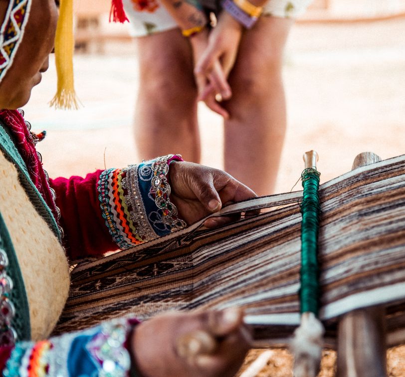a person watching a traditional weaving demonstration in peru