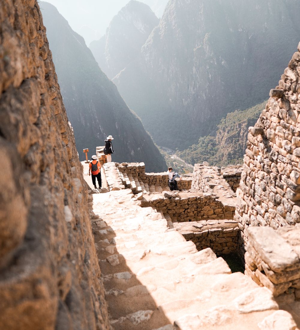 people walking up a path in machu picchu in peru