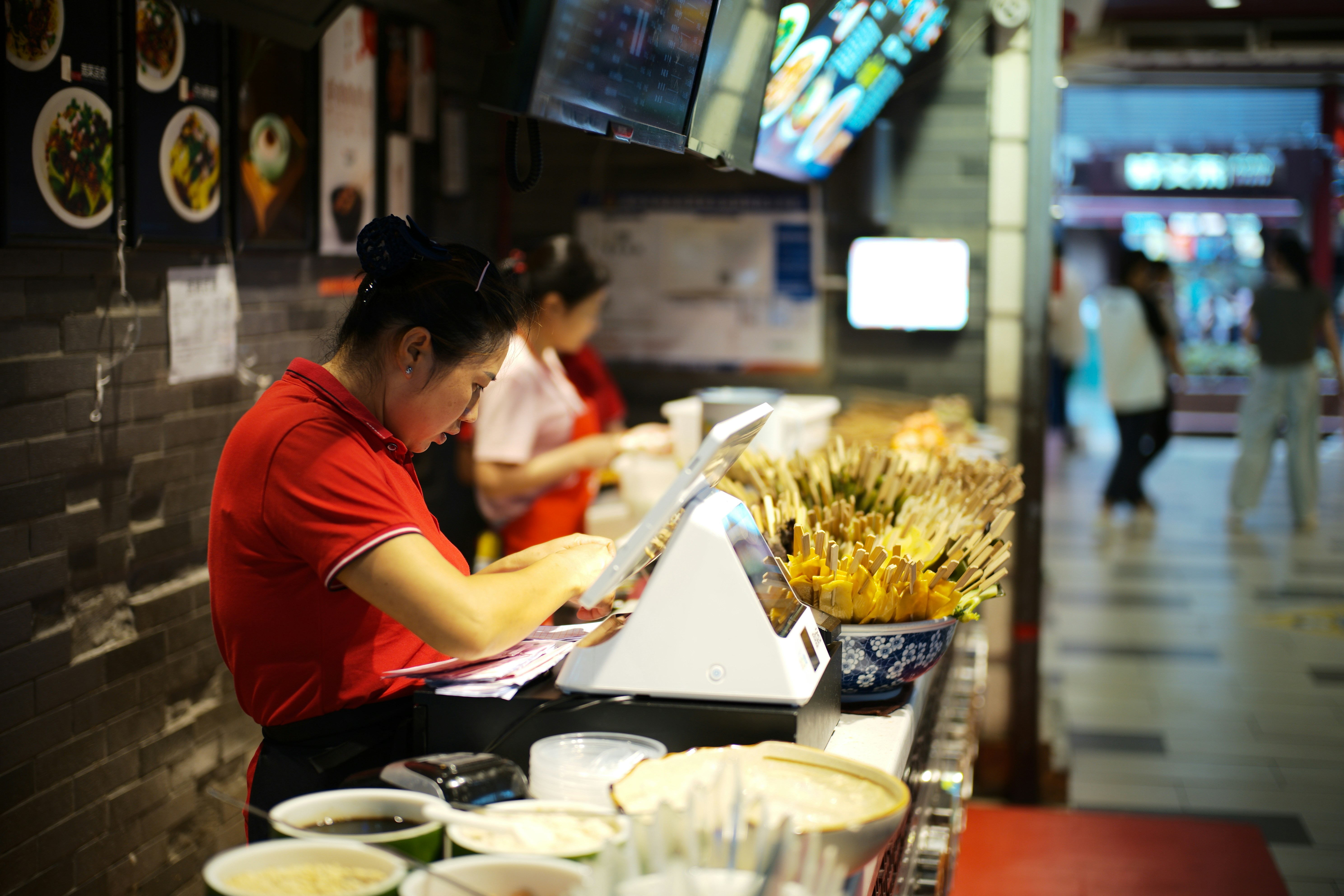 Hospitality workers serving customers at a busy restaurant counter
