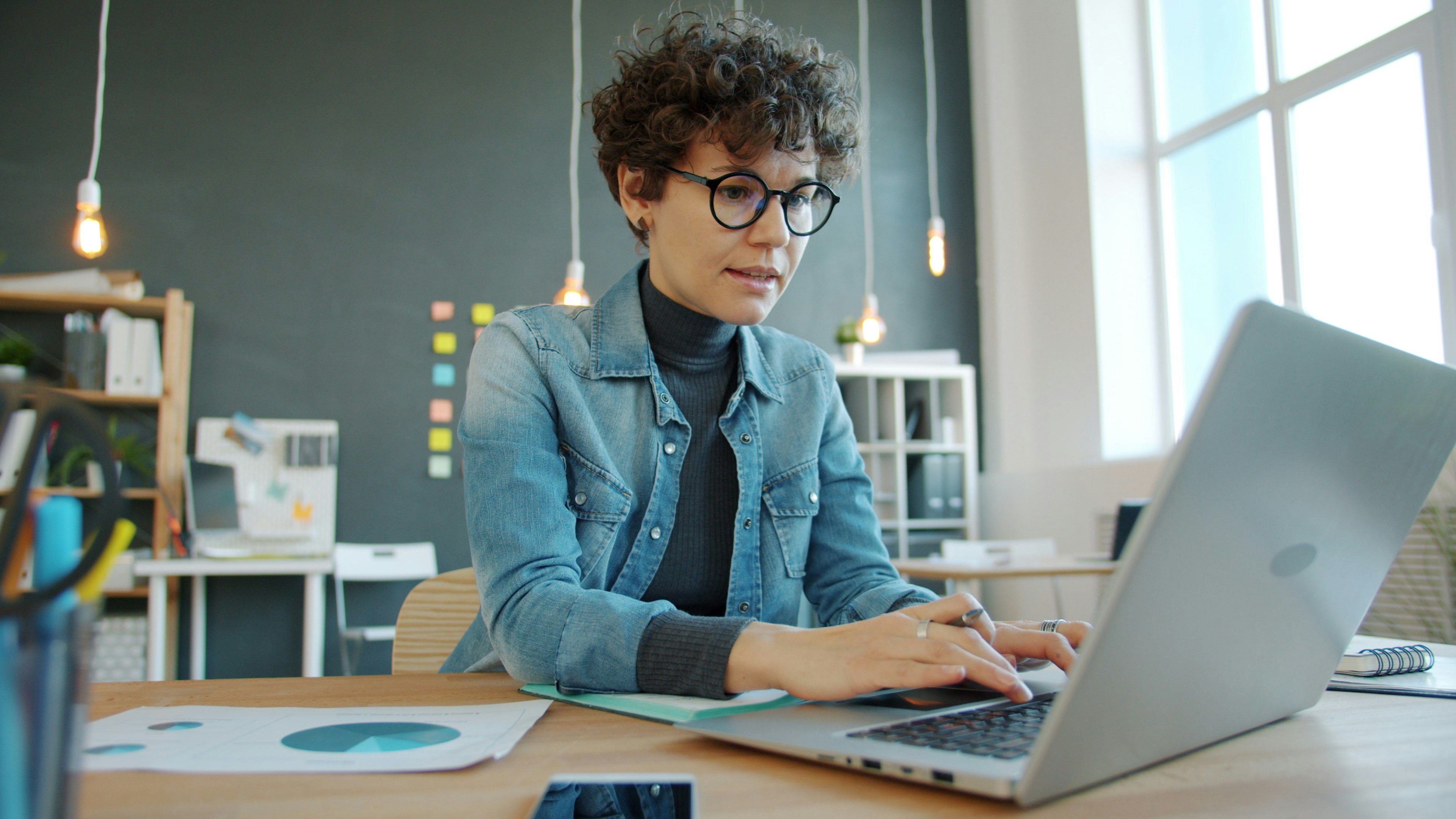 Manager reviewing workforce and pay details on a laptop at a desk