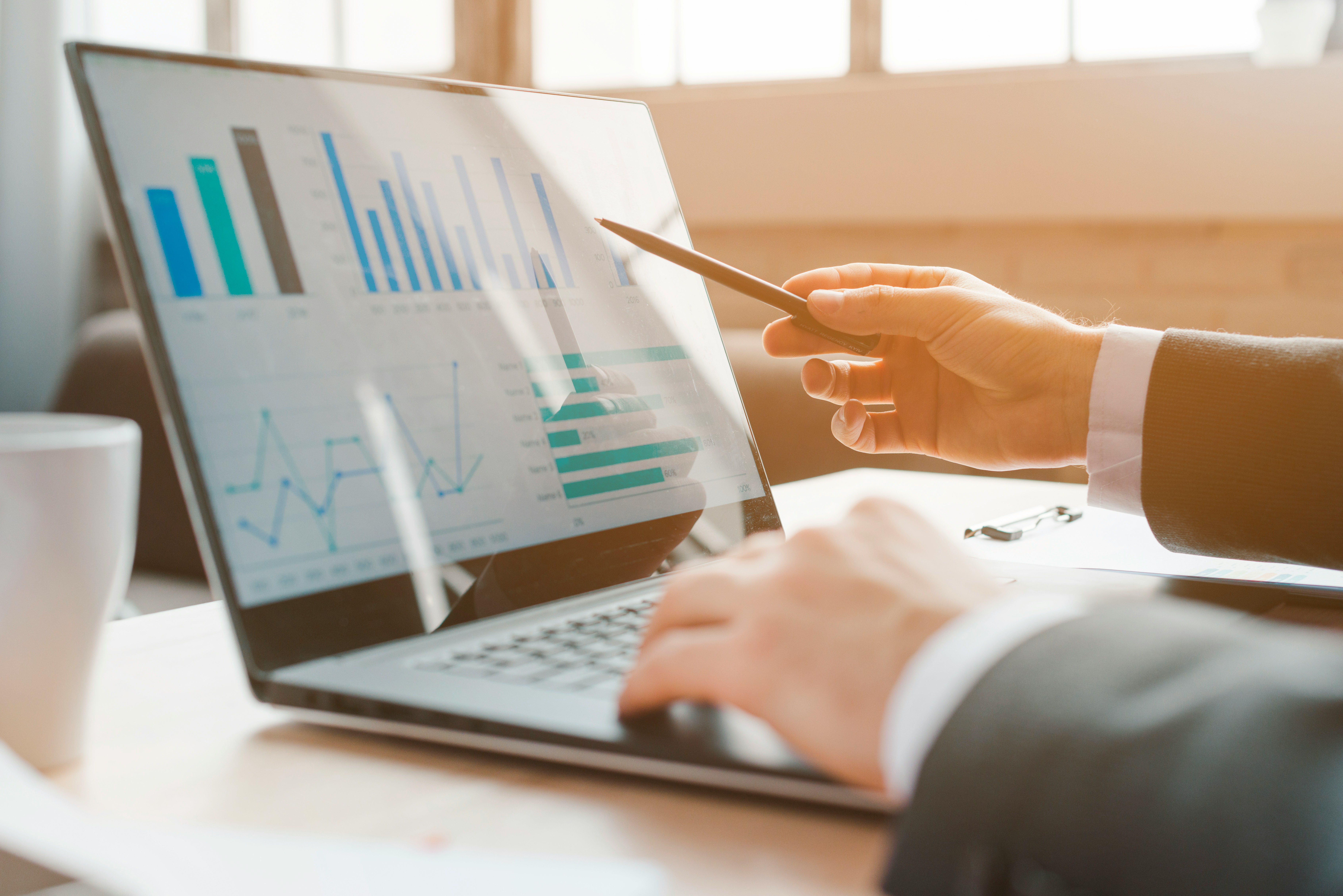 Manager reviewing business charts and data on a laptop