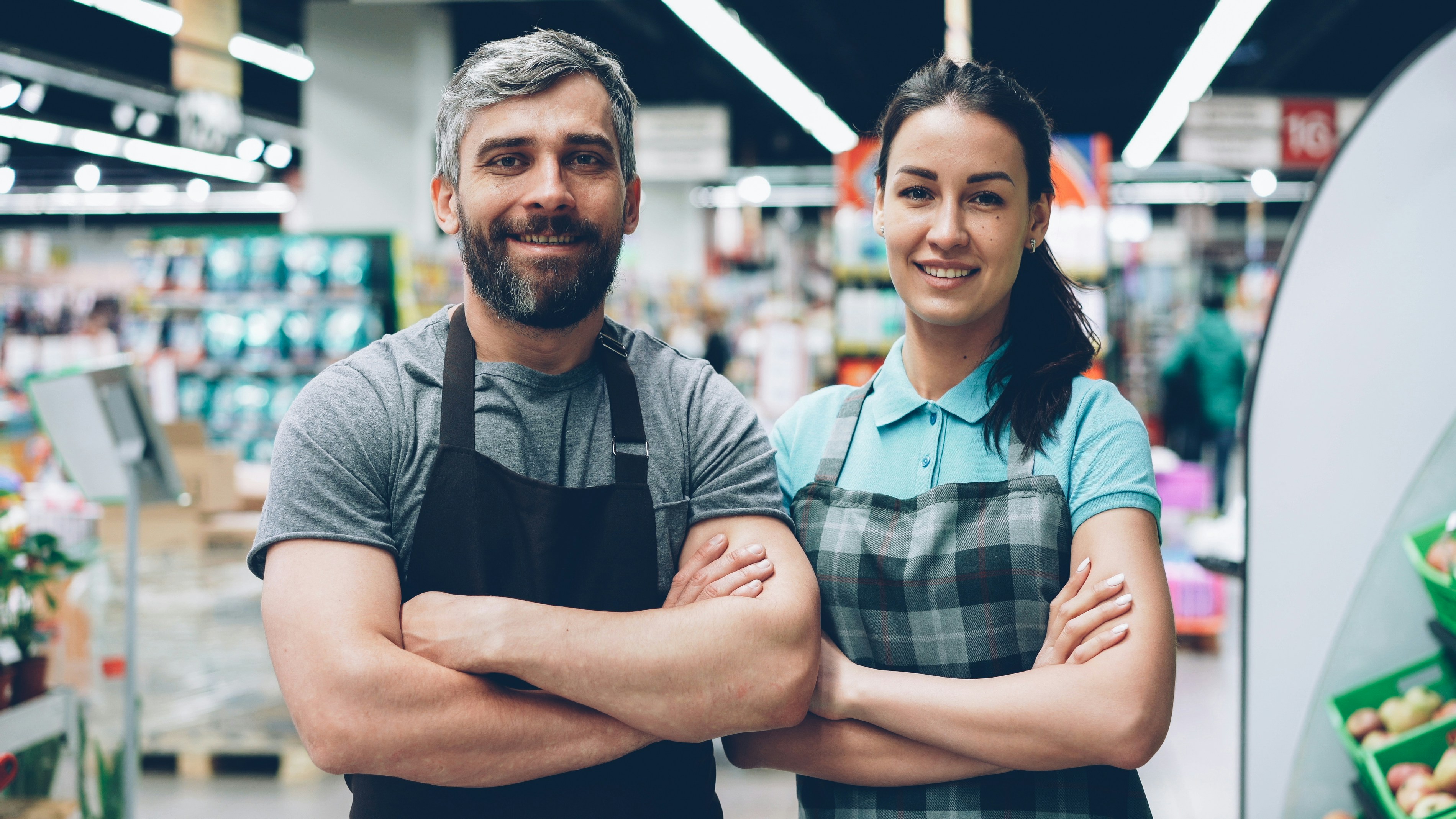 Two supermarket employees standing together on the sales floor