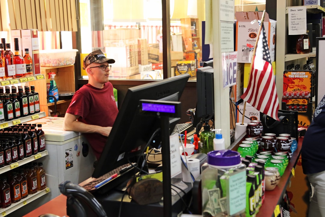 A retail worker serving a customer at a busy store checkout counter