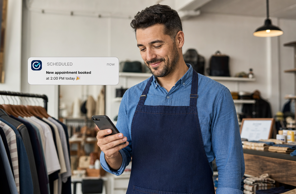 A small business owner checking a scheduling app on their smartphone in a retail shop