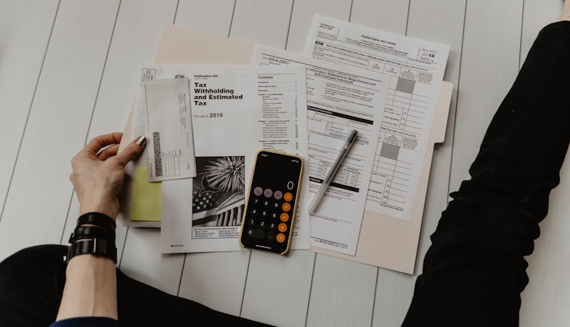 Business professional reviewing compliance documents and payroll records at a desk