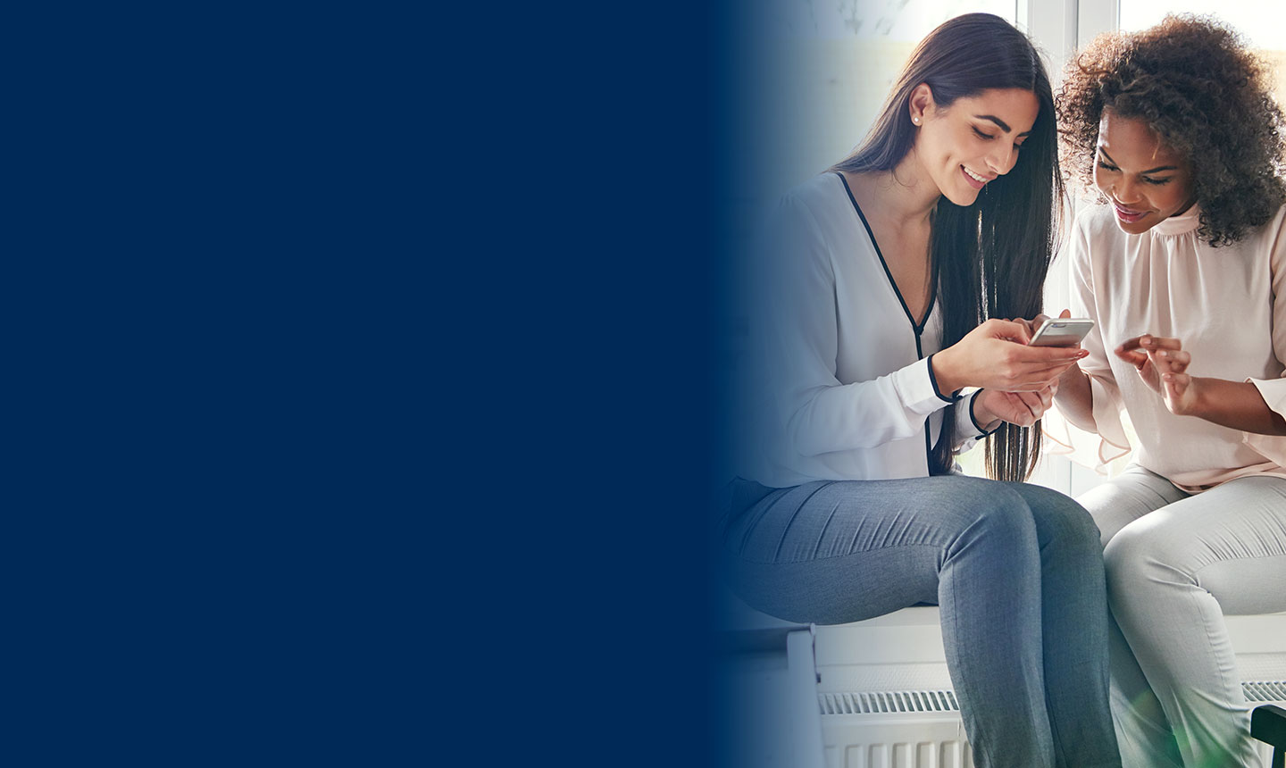 Two women looking at a cellphone together
