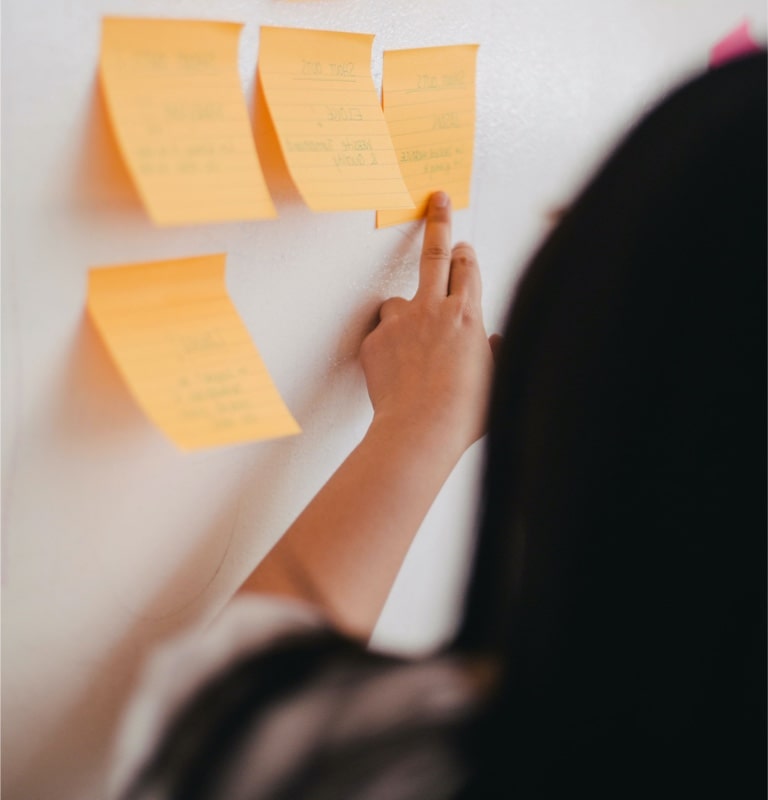Frau vor einer Post-It Wand