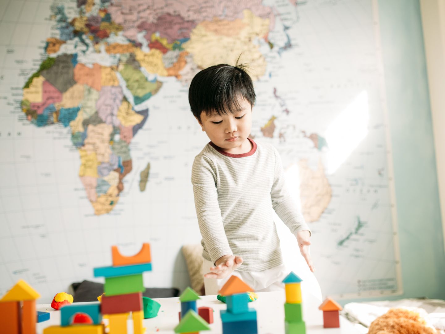 asian toddler playing with wooden toys