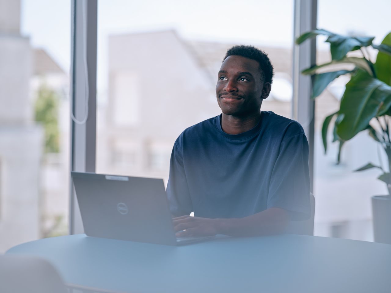 Un homme, de profil, portant une charlotte et un cache barbe. Il travaille sur un automate en zone de production.