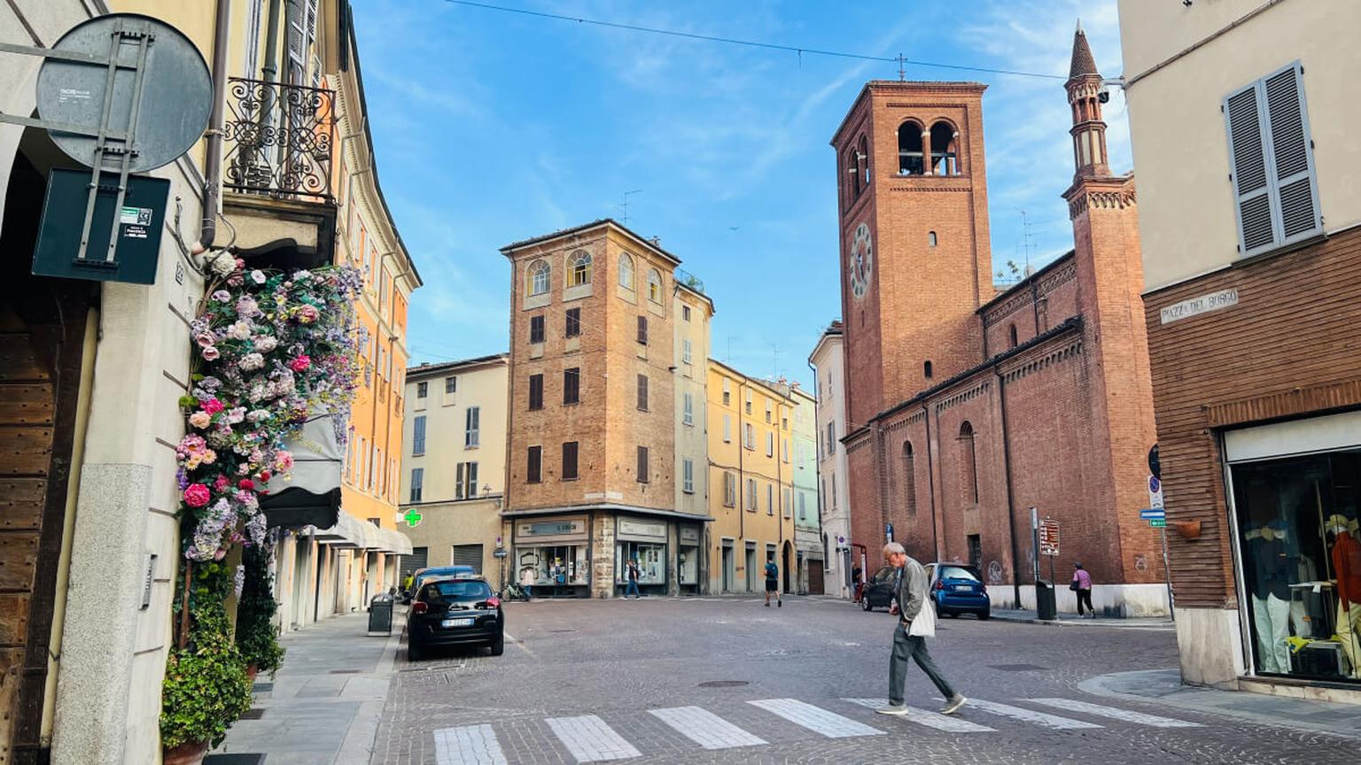 Historische Altstadtgasse mit Stadtturm und Backsteingebäuden in Italien