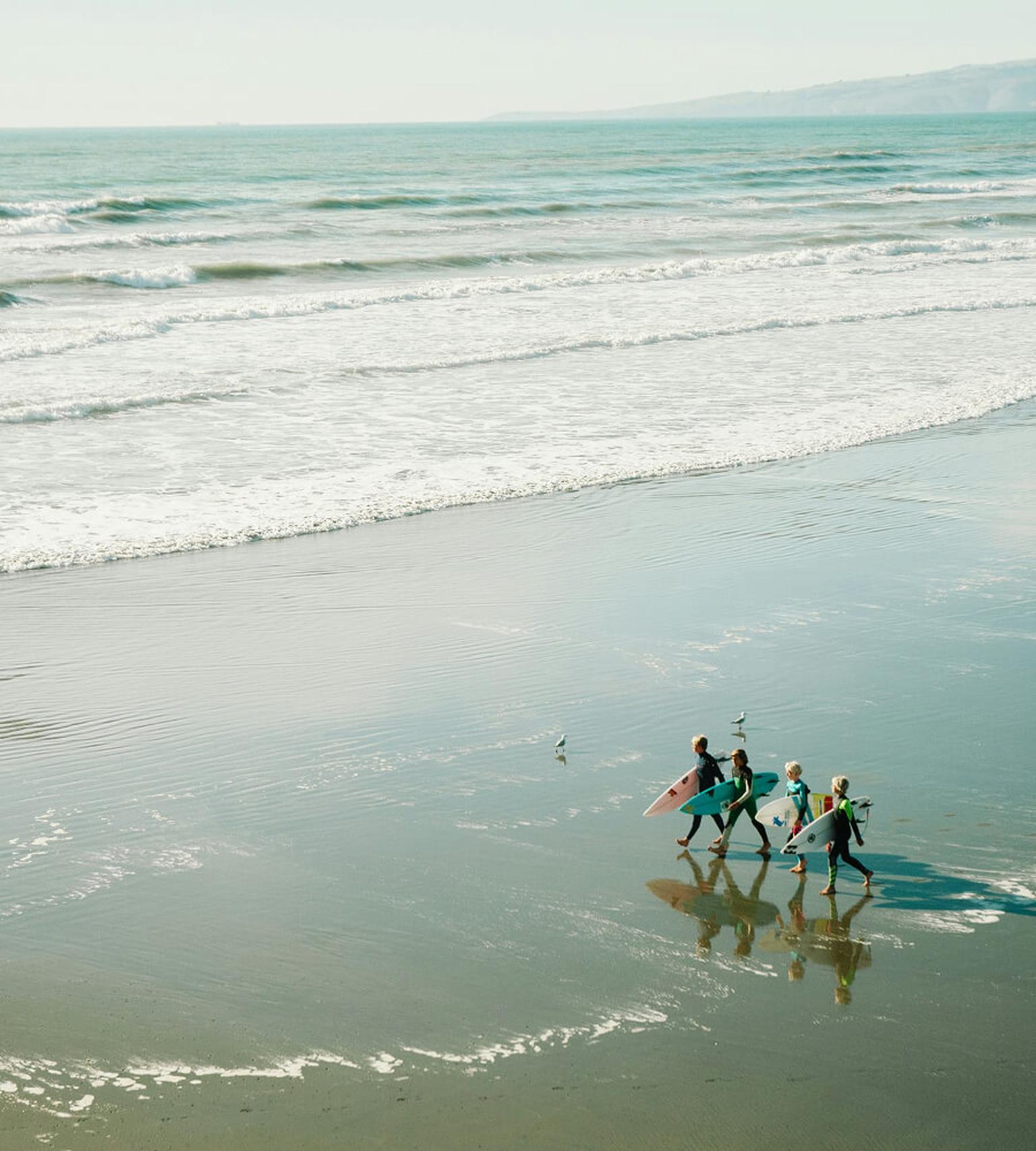 Surfers walking down the beach spotted by one of our interns abroad