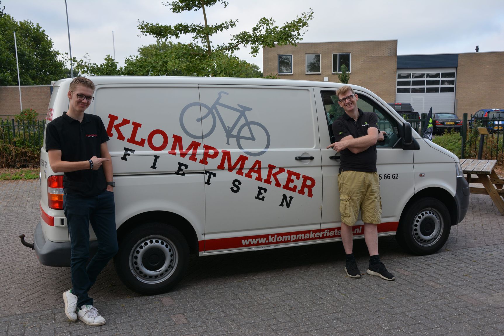 Andre en zijn zoon bij een bus van klompmaker fietsen