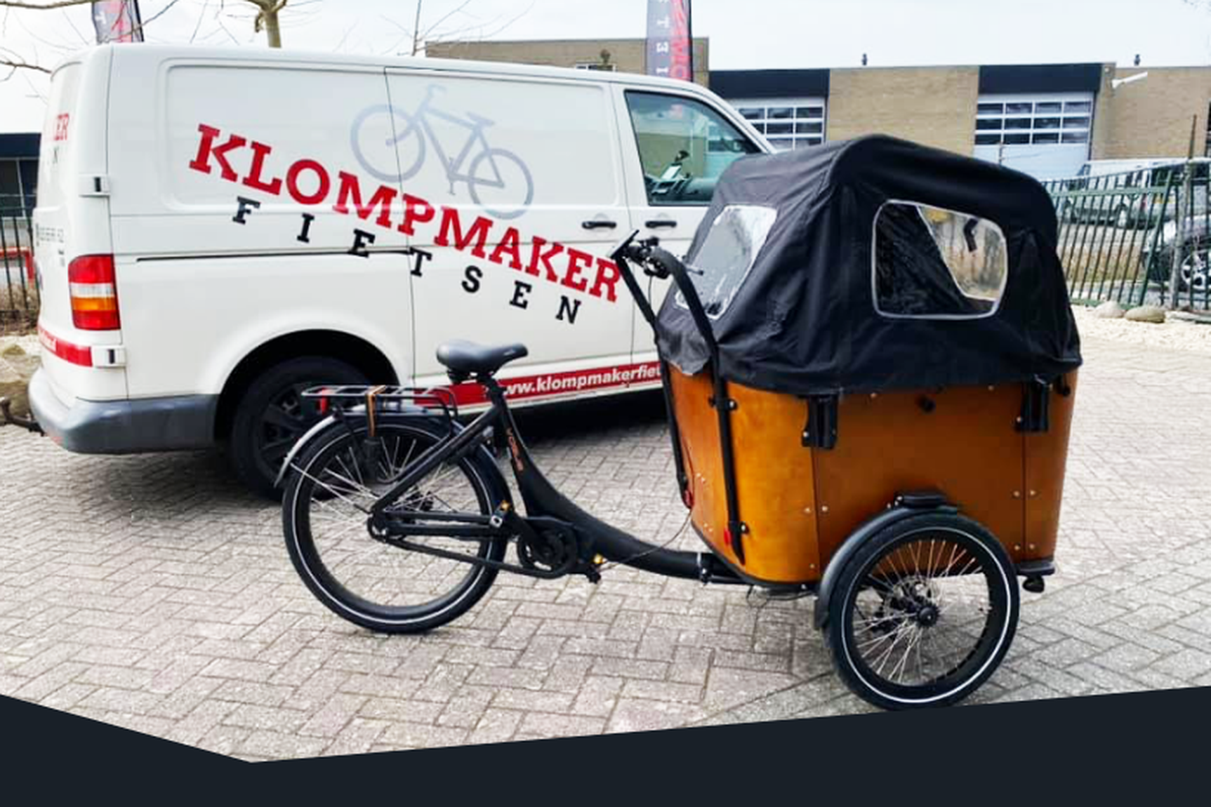 Een fiets bij een bus van Klompmaker Fietsen
