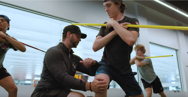Thumbnail of the Hockey Development Camp video showing a trainer helping an athlete