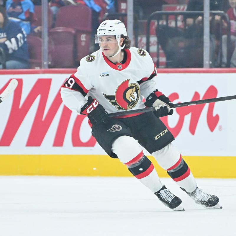 Samuel Blais in a white, red, and black Senators uniform turning on the ice.