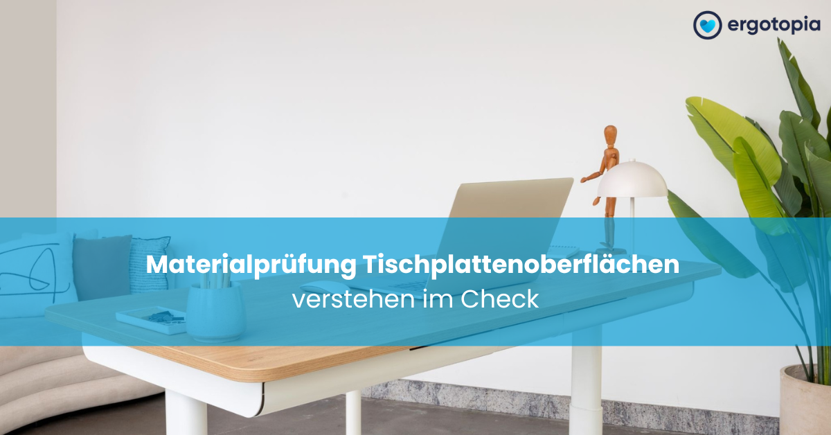 Aufgeräumter weißer Schreibtisch mit Holzplatte, Laptop, kleiner Lampe und Holzfigur vor einer begrünten, hellen Wand.