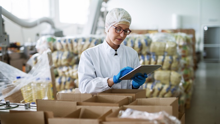 Female worker using tablet food factory imports exports