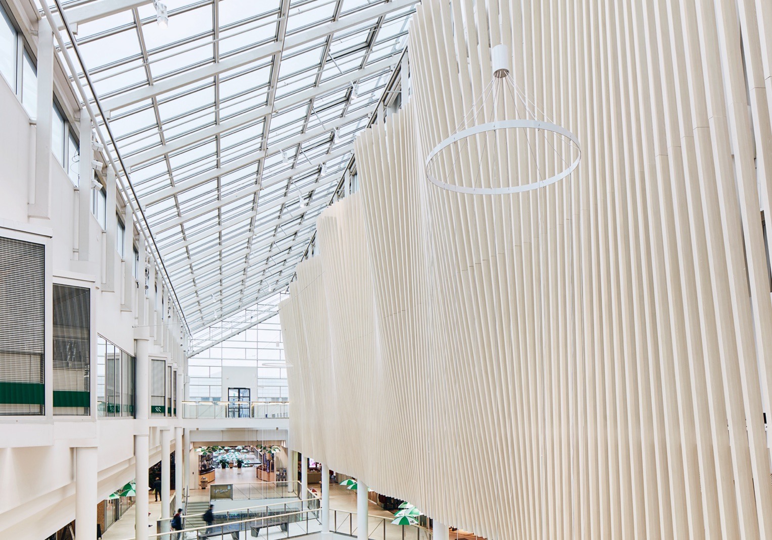 An interior space is decorated with white wooden Fortina panels and glass ceilings.