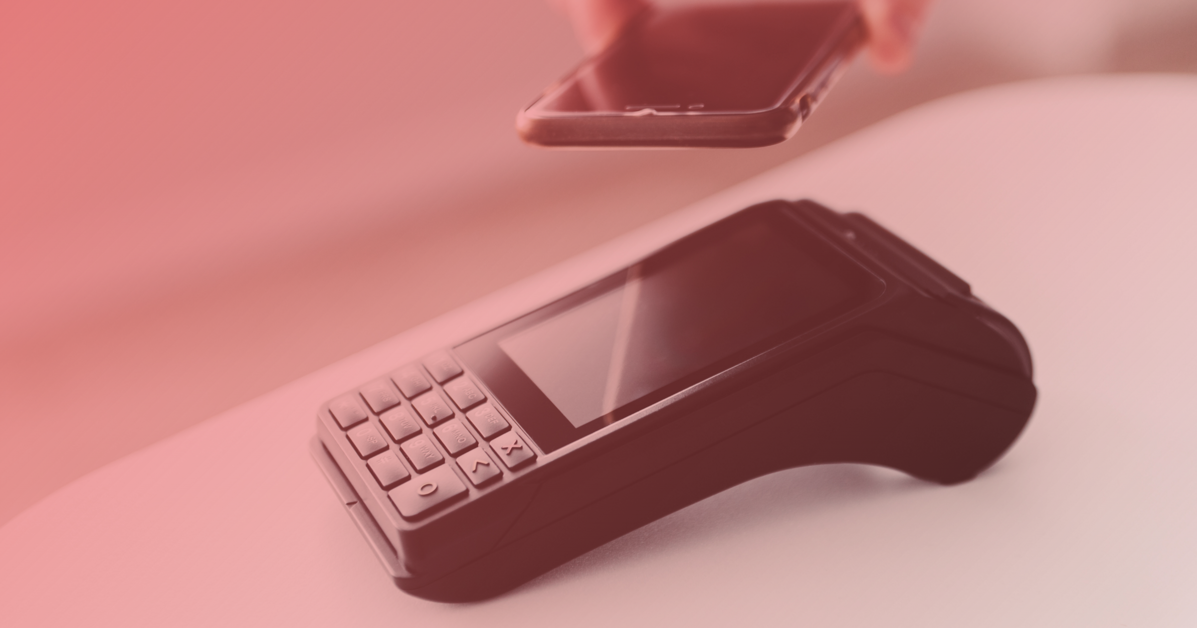 Travel expense management software: A smartphone being held over a card reader for contactless payment.