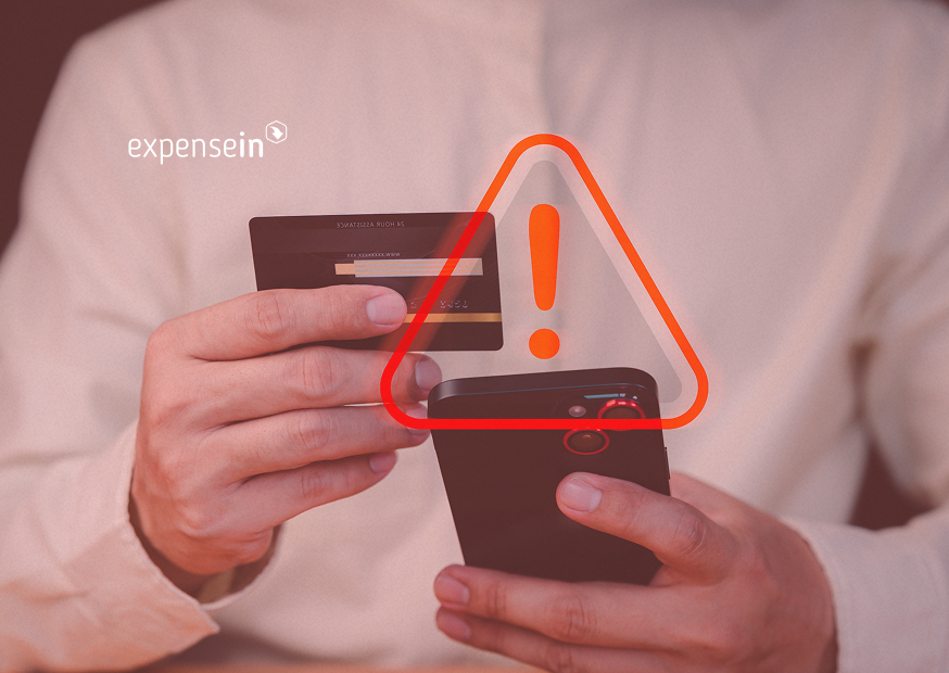 Person holding an corporate card and a smartphone, with a red warning symbol overlay.