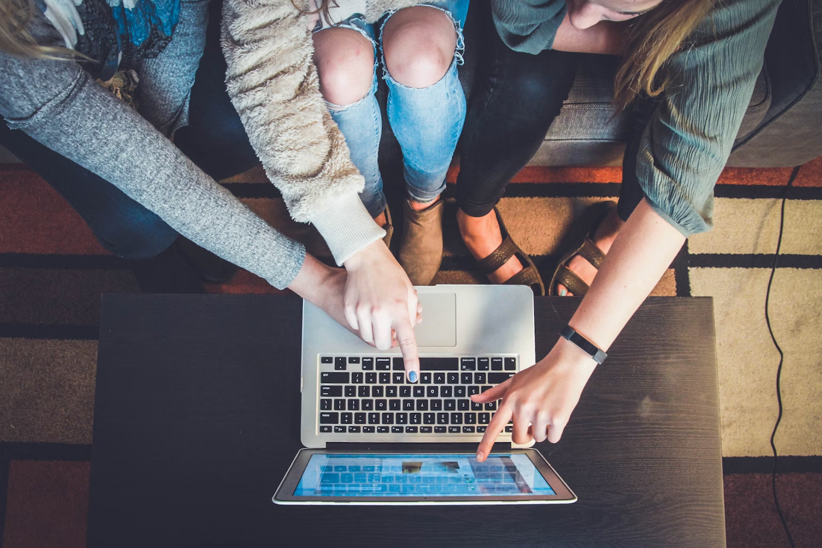 a team consists of three people discussing about seamless communication in front of a laptop