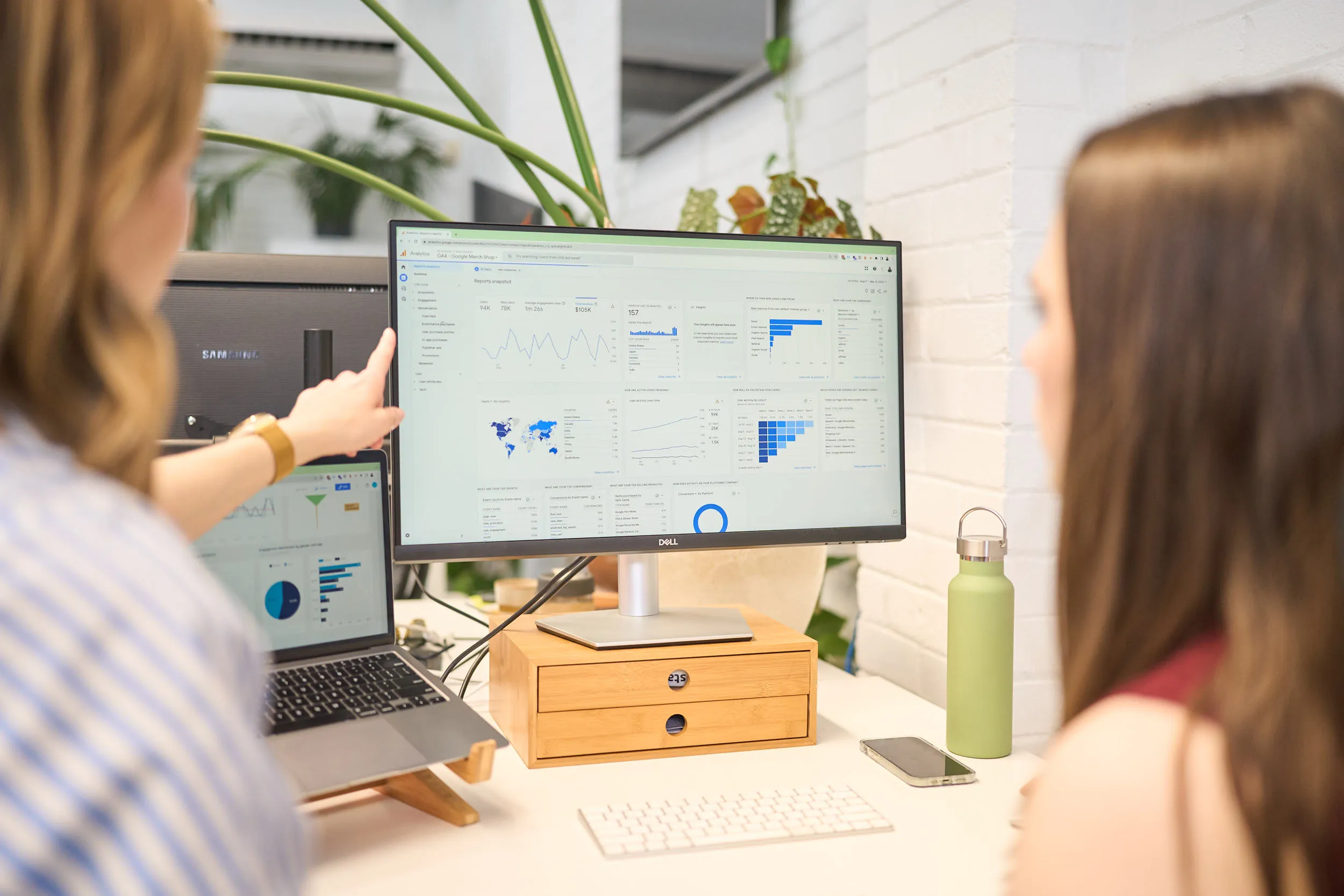 Two women look at website analytics and data on a computer screen