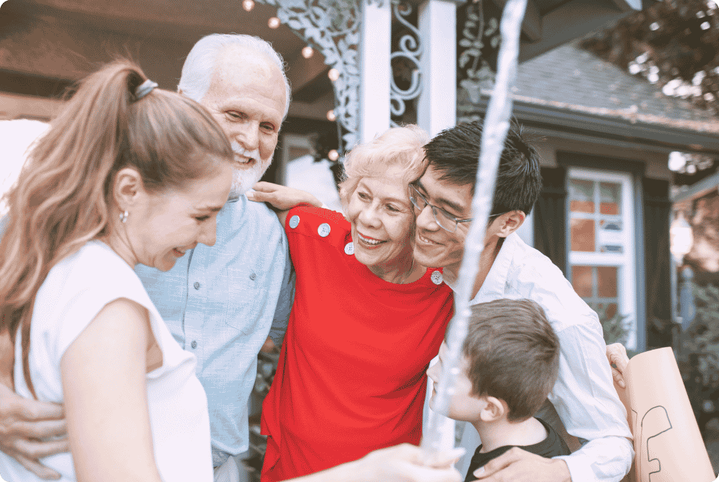 Group of five smiling and embracing outside, capturing a joyful and affectionate moment.