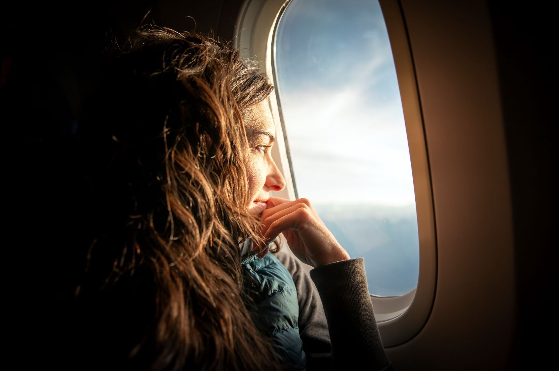 Frau blickt aus dem Fenster eines Flugzeugs