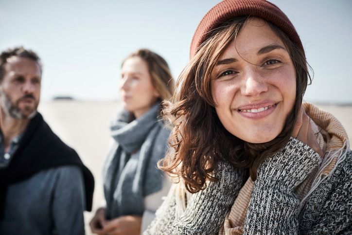 Den passenden Fonds finden: Junge Frau mit brauner Mütze sowie im Hintergrund eine weitere Frau und ein Mann