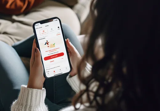 Osoba, která drží smartphone zobrazující rozhraní doručovací aplikace, představuje karikaturního kurýra a možnosti objednání jídla.